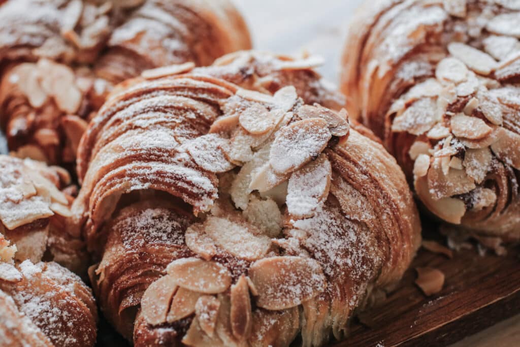 Almond Croissant Bakery homemade on the Table. Traditional French breakfast tray with gold and crispy croissants.