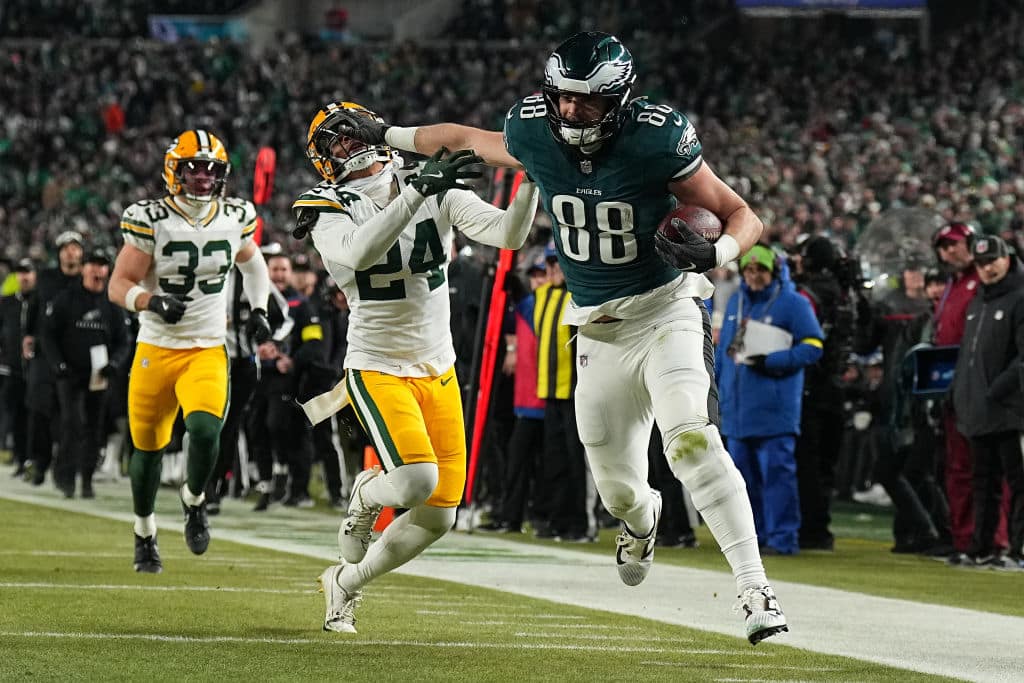 PHILADELPHIA, PENNSYLVANIA - JANUARY 12: Dallas Goedert #88 of the Philadelphia Eagles stiff arms Carrington Valentine #24 of the Green Bay Packers before running for a third quarter touchdown during the NFC Wild Card Playoff at Lincoln Financial Field on January 12, 2025 in Philadelphia, Pennsylvania.