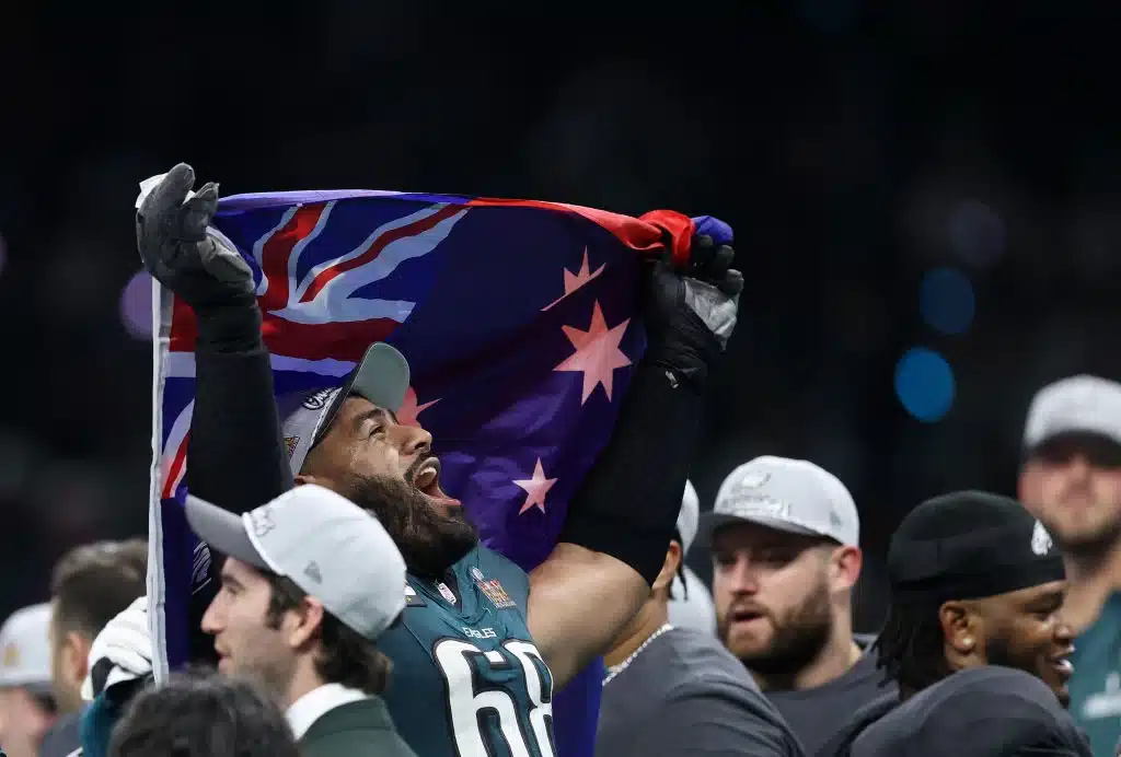 Jordan Mailata #68 of the Philadelphia Eagles celebrates after beating the Kansas City Chiefs 40-22 to win Super Bowl LIX waiving the flag of Australia