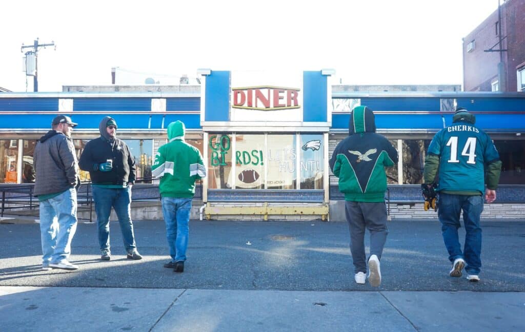 Philadelphia Eagles fans gather outside of the Broad Street Diner in their Eagles gear.