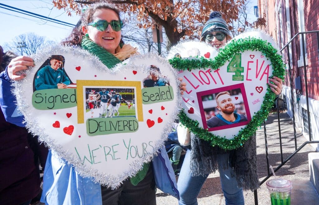 Maddie Smith, left, and Colleen Caprario, right, both from Philadelphia, show their homemade signs