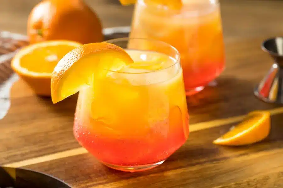 Colorful orange cocktail with an orange wedge for recipes for the big game